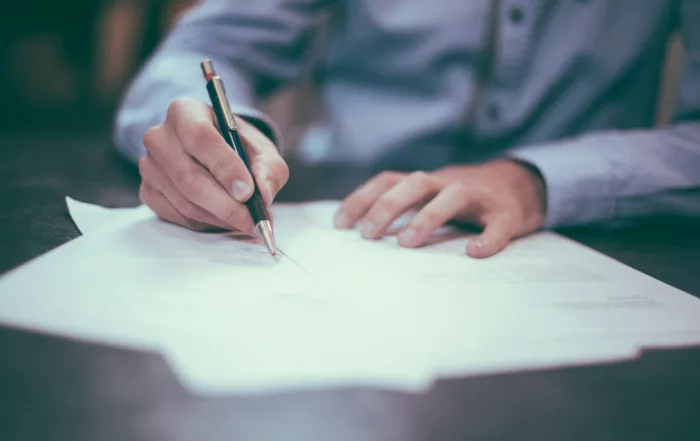 Firma de un contrato de cuentas en participación inmobiliarias sobre una mesa
