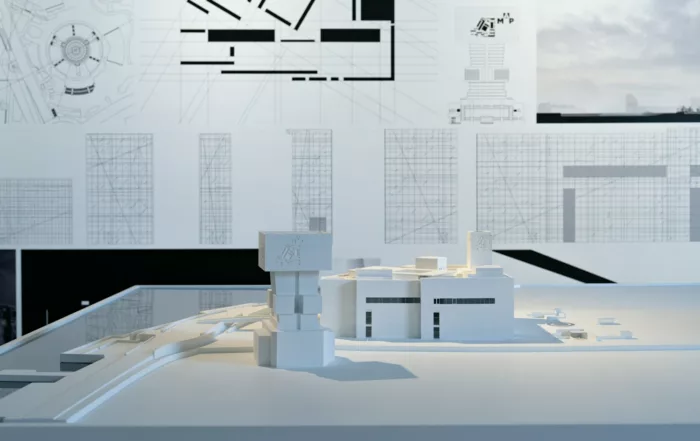 Maqueta de un edificio y planos de un proyecto inmobiliario financiado con deuda privada