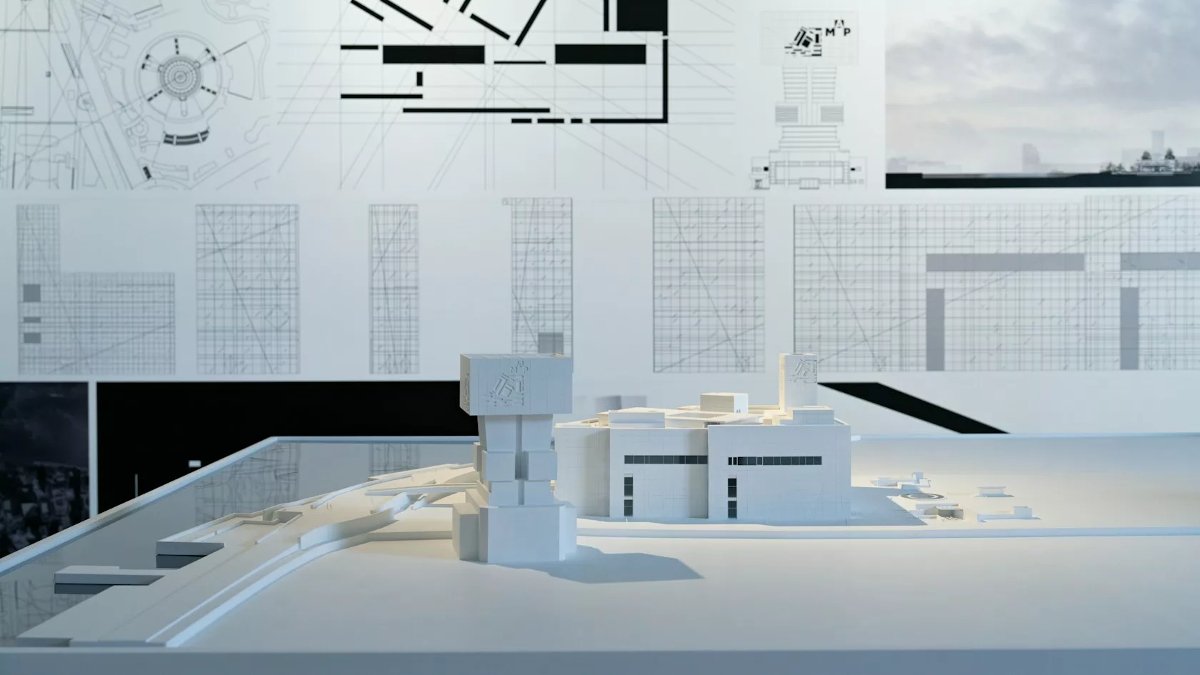 Maqueta de un edificio y planos de un proyecto financiado con deuda privada inmobiliaria en España
