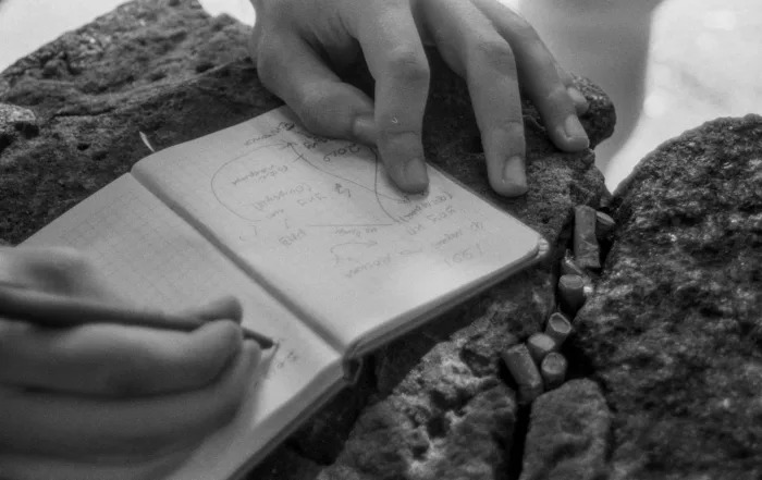 Manos señalando esquemas en una libreta abierta durante una sesión de planificación