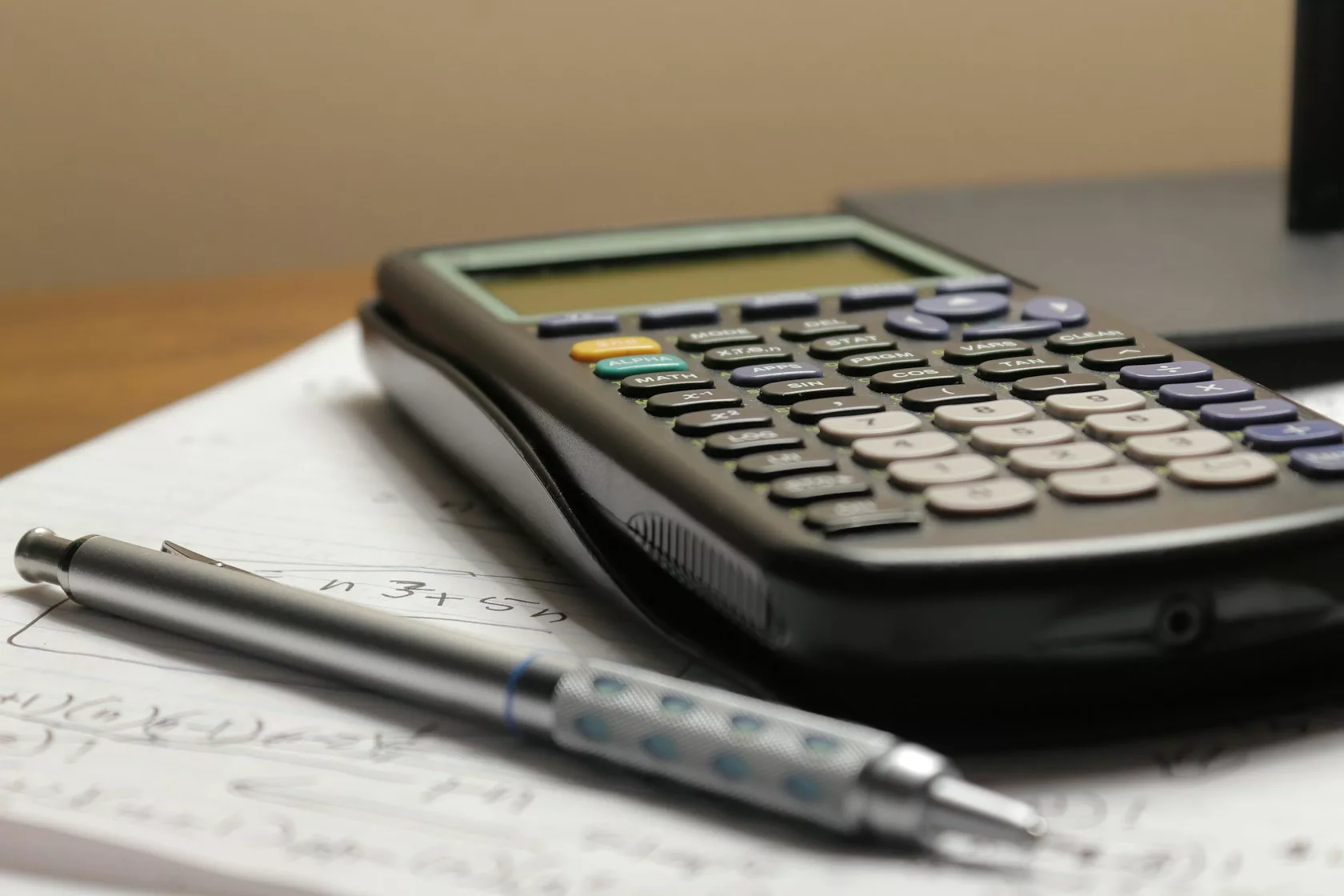 Calculadora y bolígrafo sobre un documento: intereses PIK en deuda privada