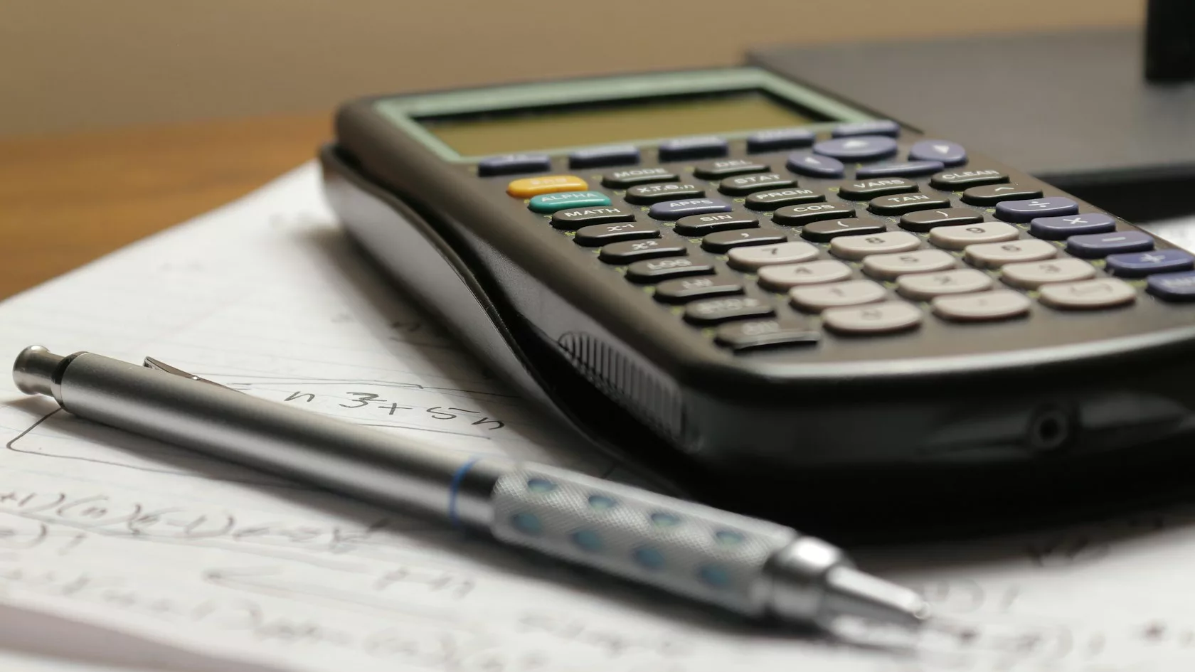 Calculadora y bolígrafo sobre papel para calcular la rentabilidad real del ahorro frente a la inflación