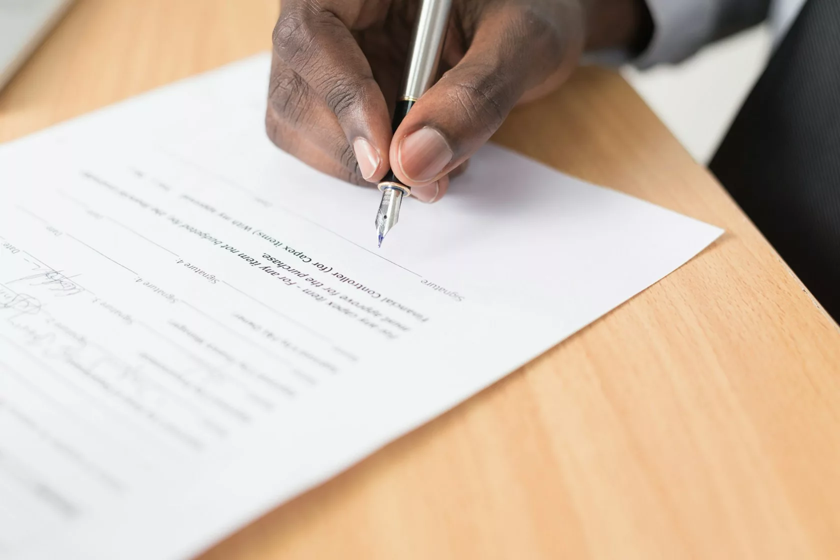 Persona firmando un contrato sobre una mesa: covenants en deuda privada inmobiliaria