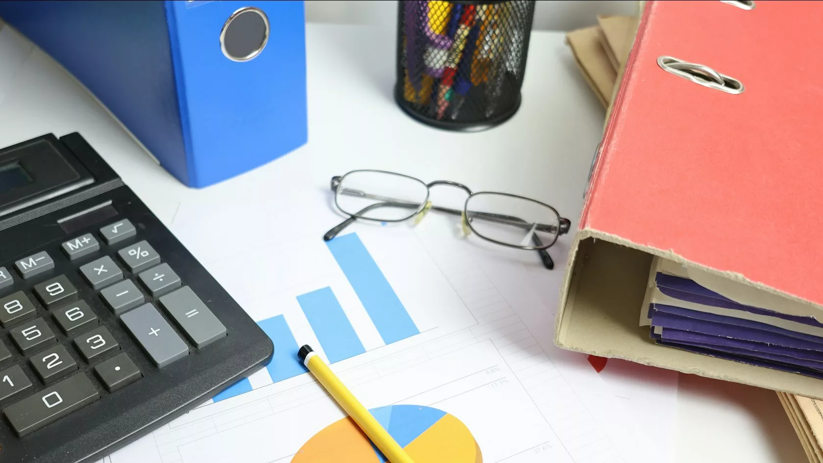 Escritorio con calculadora, gráficos y carpetas para analizar el direct lending en Europa