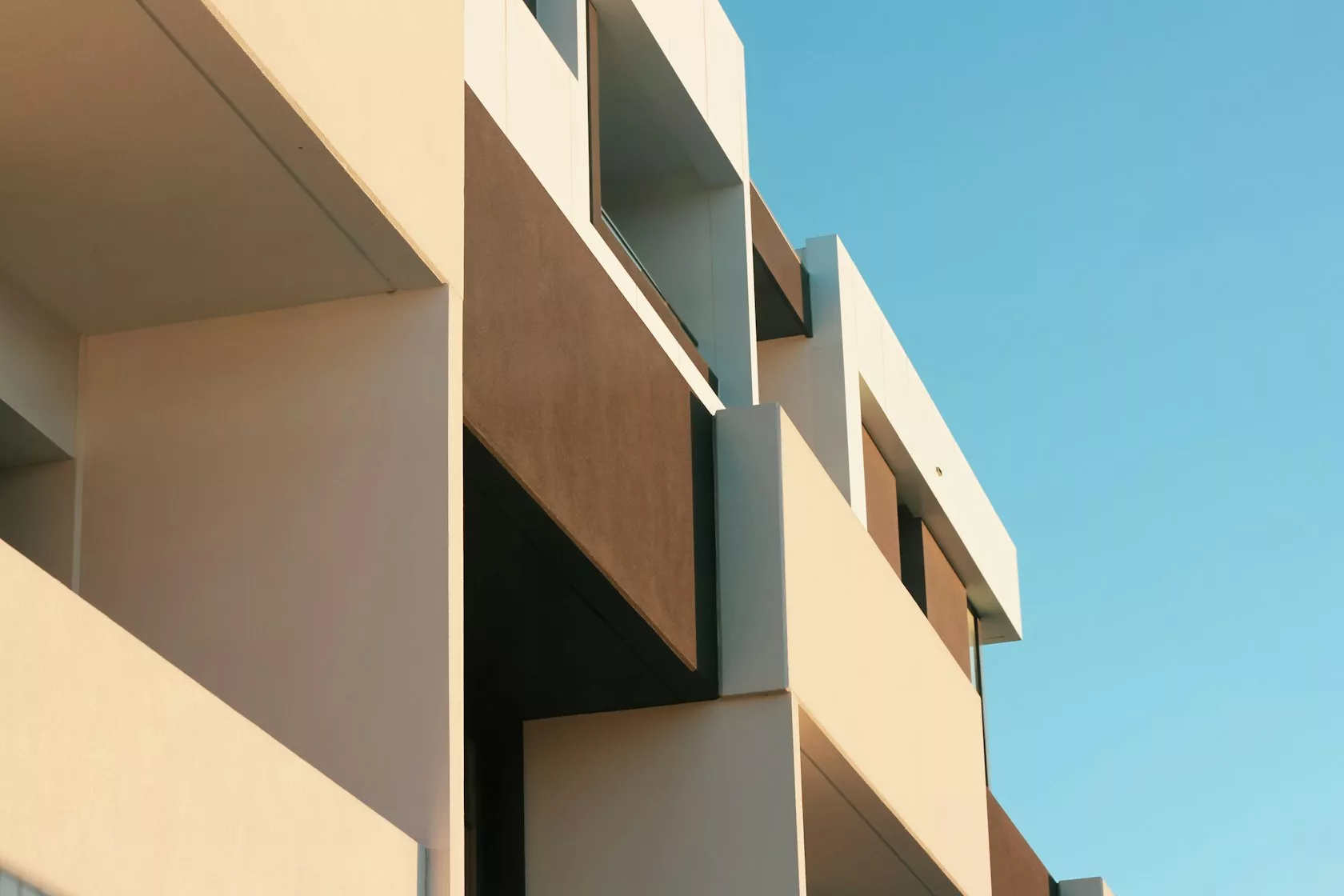 Edificio de viviendas bajo un cielo azul, activo inmobiliario que respalda una inversión en deuda privada