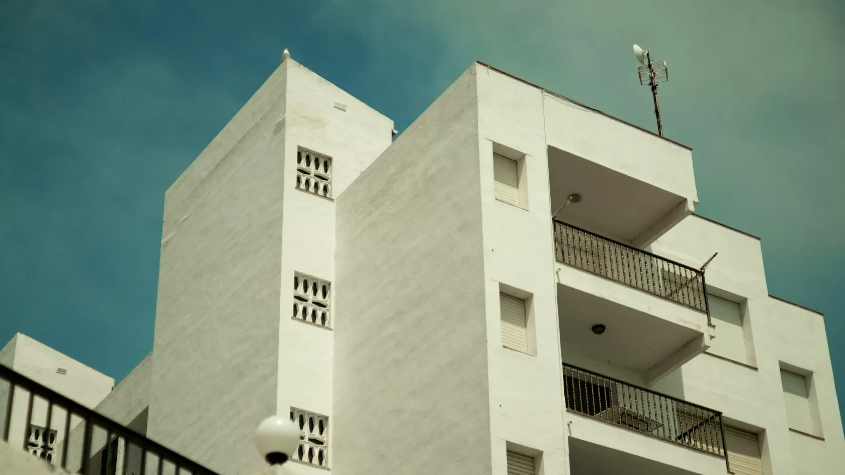 Edificio de viviendas blanco bajo cielo despejado, activo inmobiliario detrás de una inversión en deuda privada