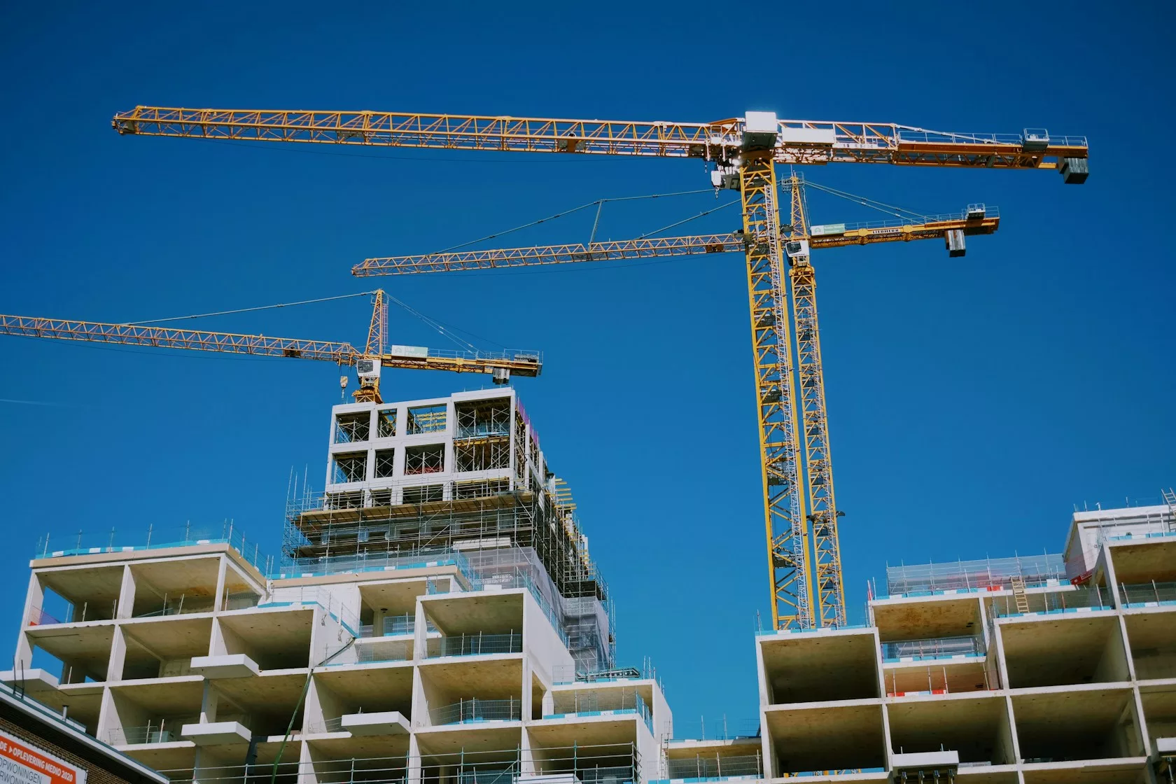 Grúas sobre un edificio de viviendas en construcción: financiación alternativa en la promoción residencial