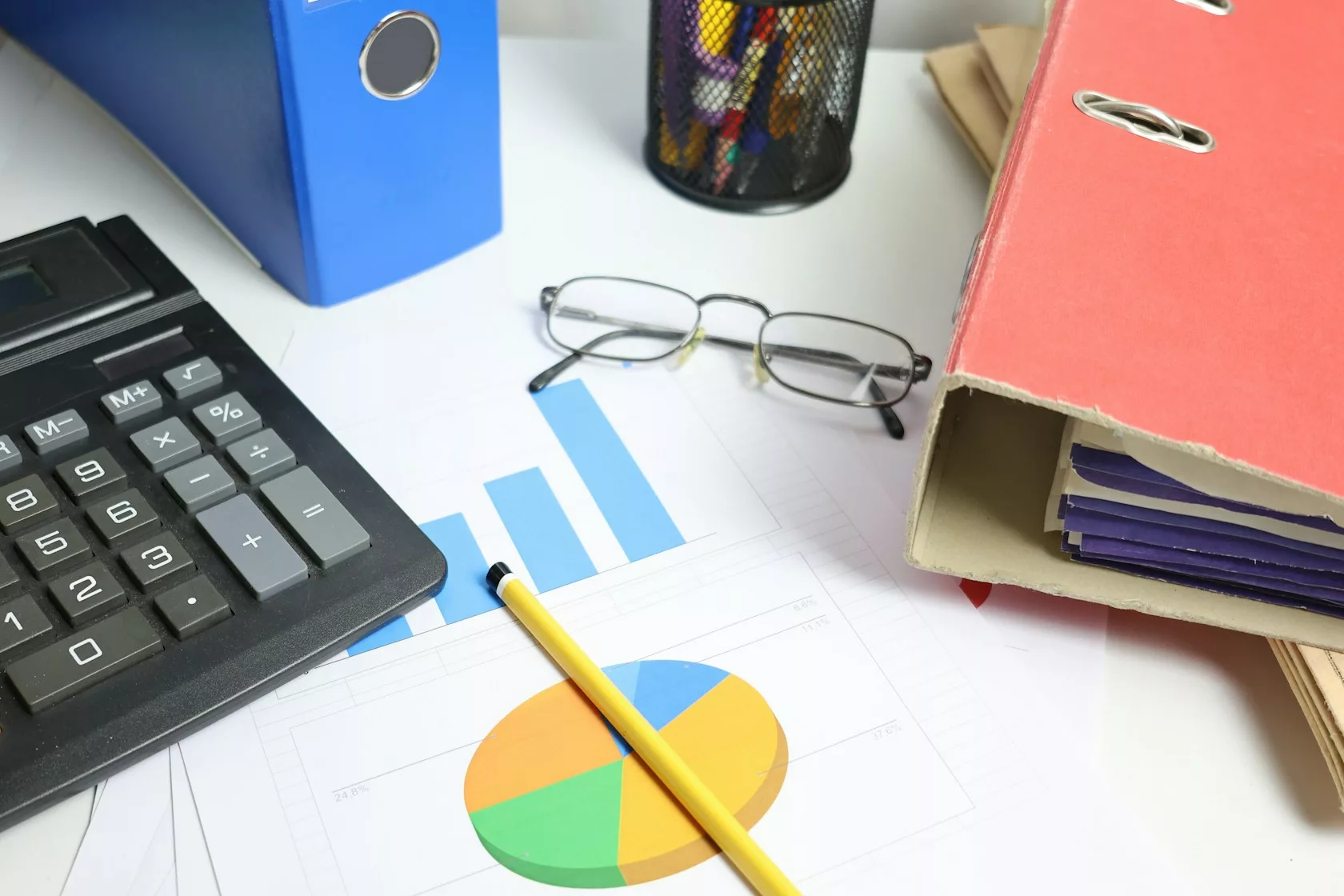 Mesa de trabajo con calculadora, carpetas y gráficos para analizar una cartera de NPL