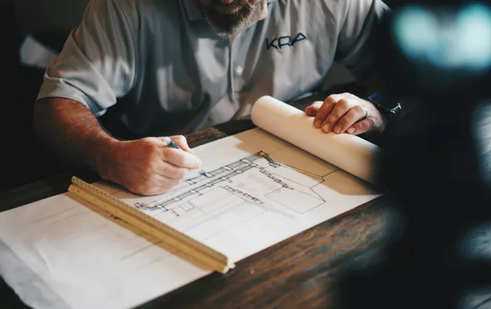 Planos de arquitectura sobre una mesa, base de un proyecto de promoción que busca financiación